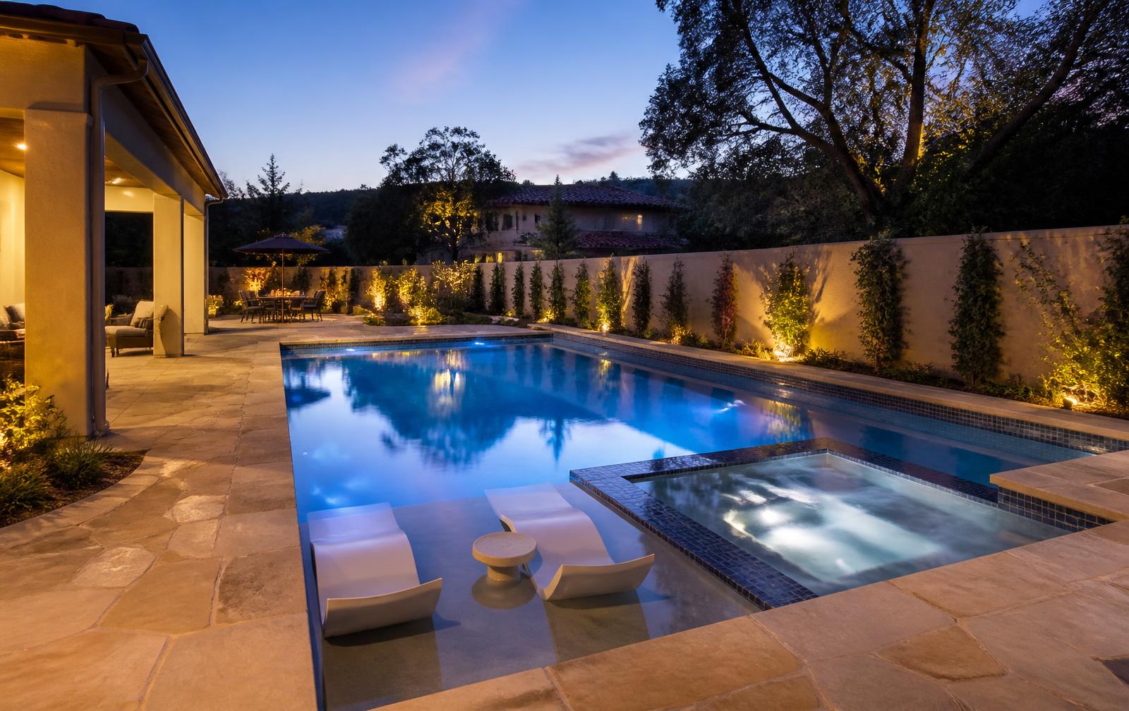 New backyard swimming pool with spa and stone decking